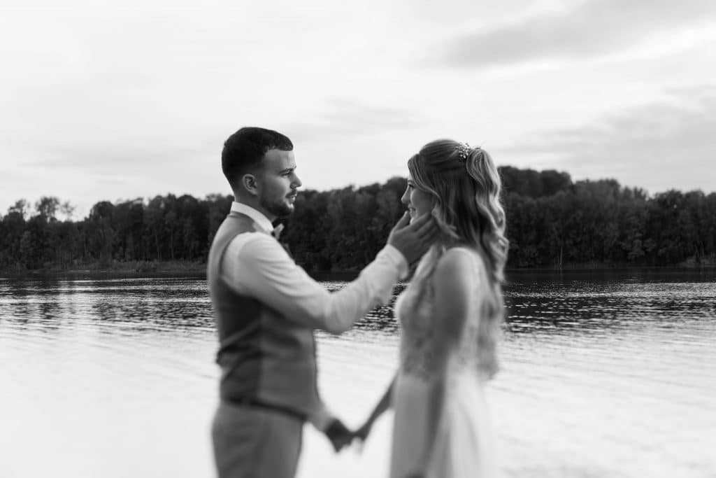 Candid Shot of bride and groom standing at the Lake. Editorial Wedding Photography. Luxury Wedding.