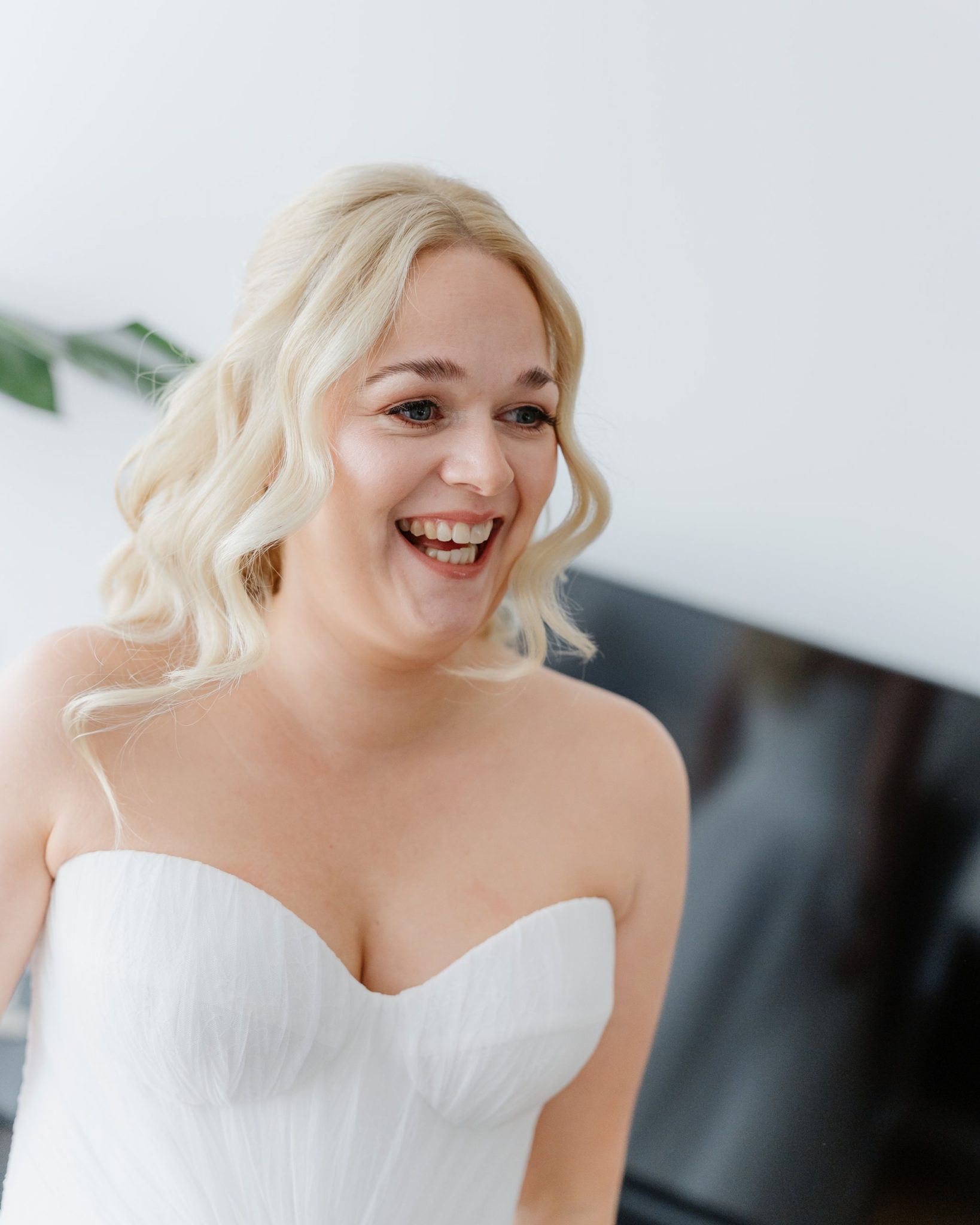Braut lacht im Brautkleid beim Getting Ready