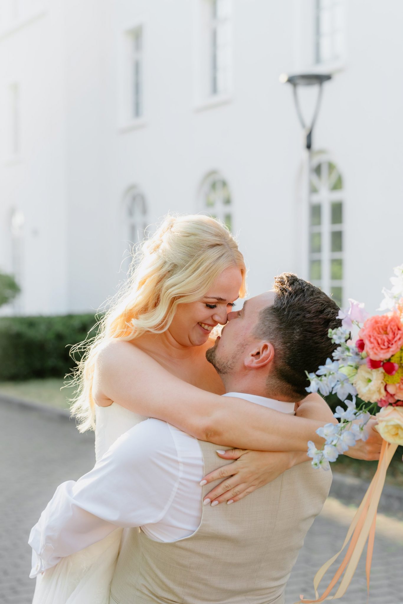 Bräutigam hebt die Braut beim Sunset-Shooting hoch