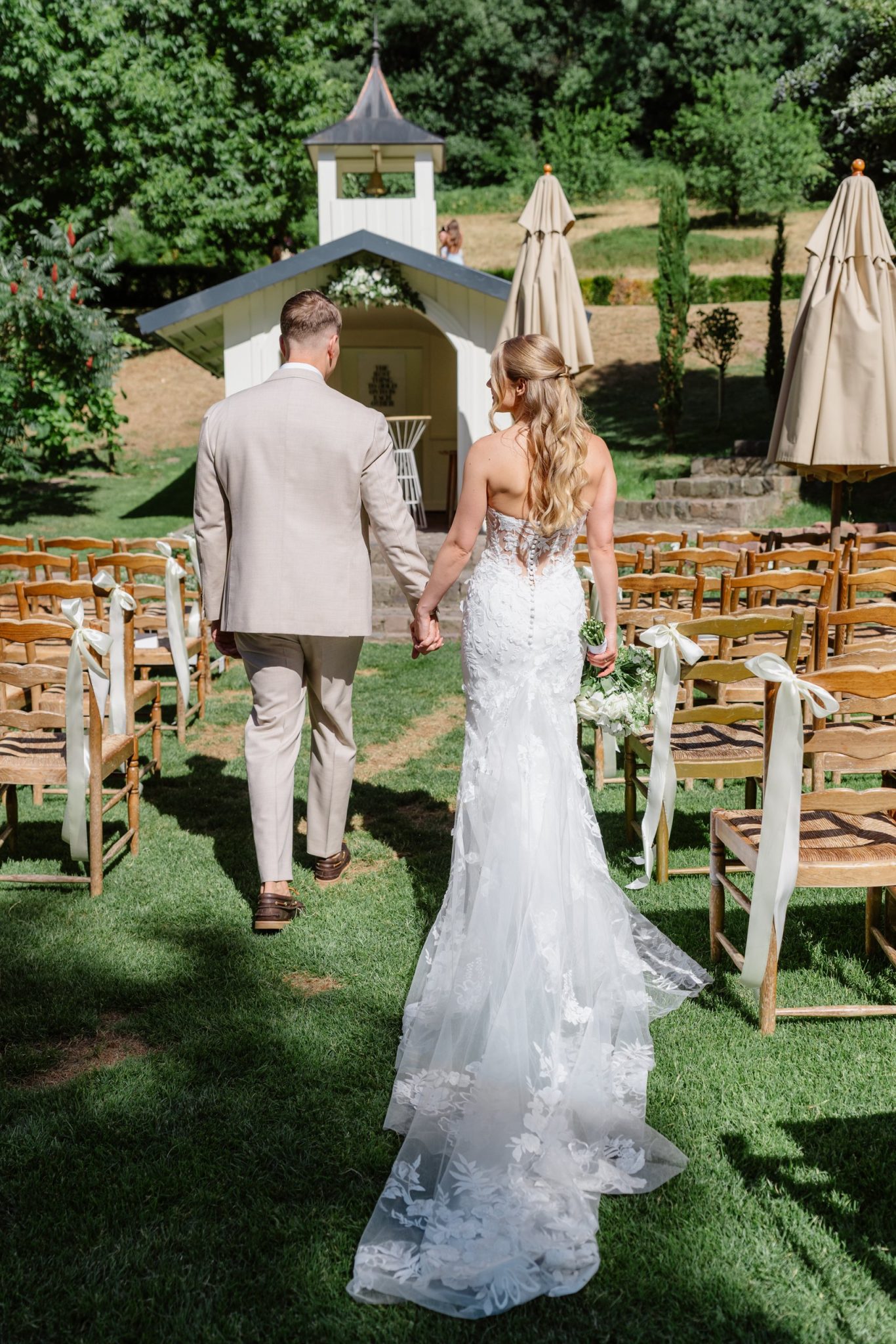 Svenja und Julian gehen Hand in Hand auf die weiße Kapelle zu