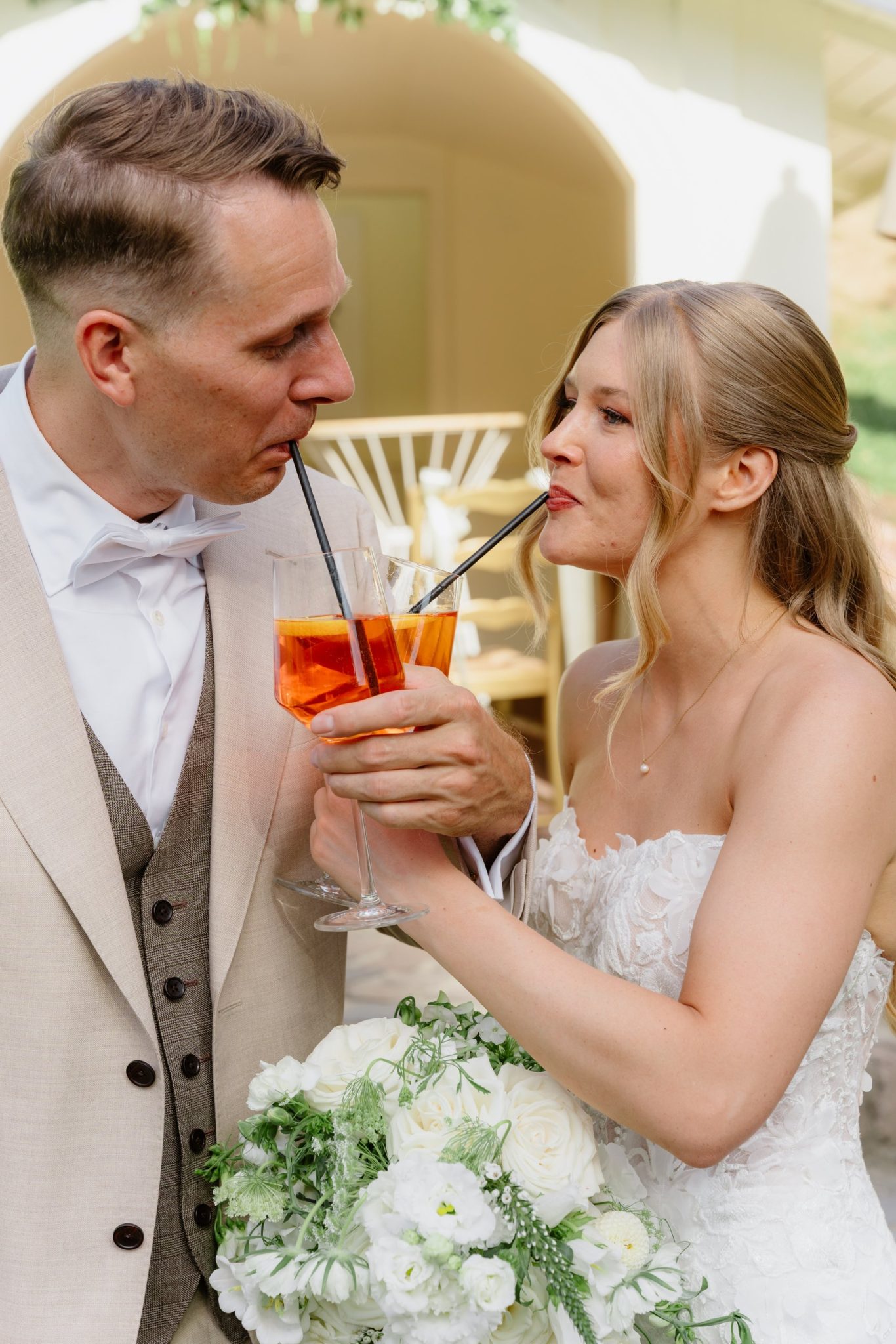 Svenja und Julian teilen sich einen Aperol mit zwei Strohhalmen